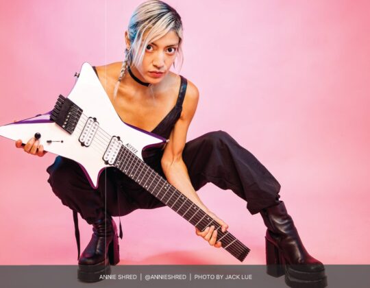 Annie Shred posing with electric guitar for the August 2023 Guitar Girl Magazine Calendar