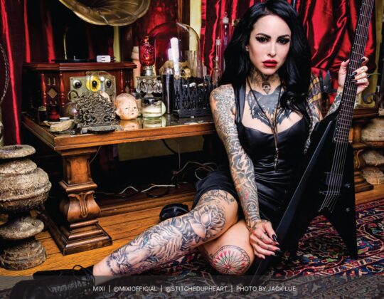 Mixi posing with black electric guitar for the October 2023 Guitar Girl Magazine Calendar