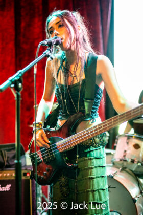 girl playing bass guitar onstage