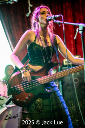girl playing bass guitar onstage