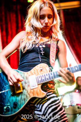 girl playing guitar onstage