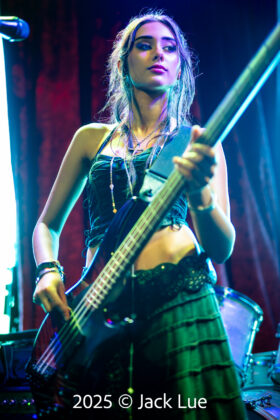 girl playing bass guitar onstage