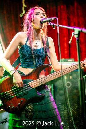 girl playing bass guitar onstage