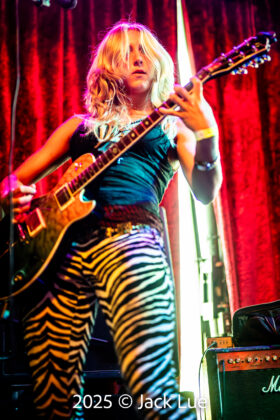 girl playing guitar onstage