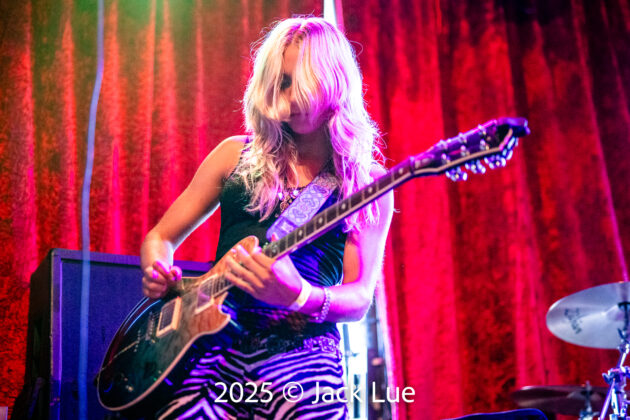 girl playing guitar onstage