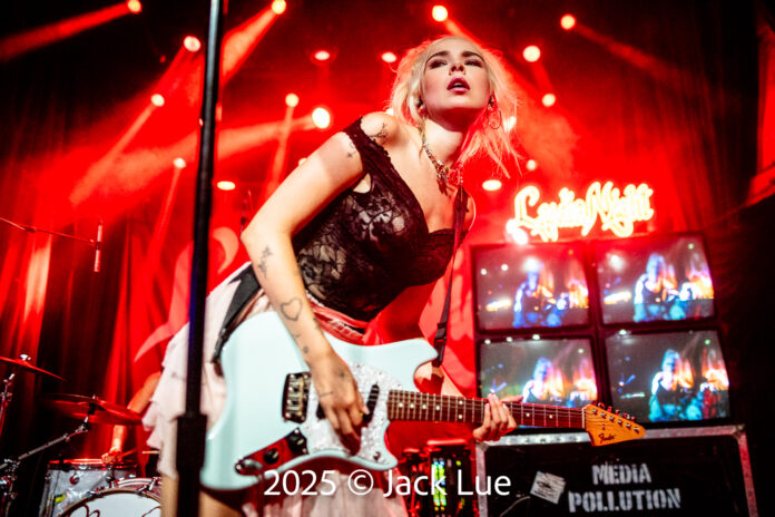 girl playing guitar onstage
