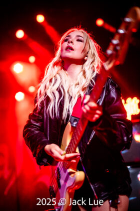 girl playing guitar onstage