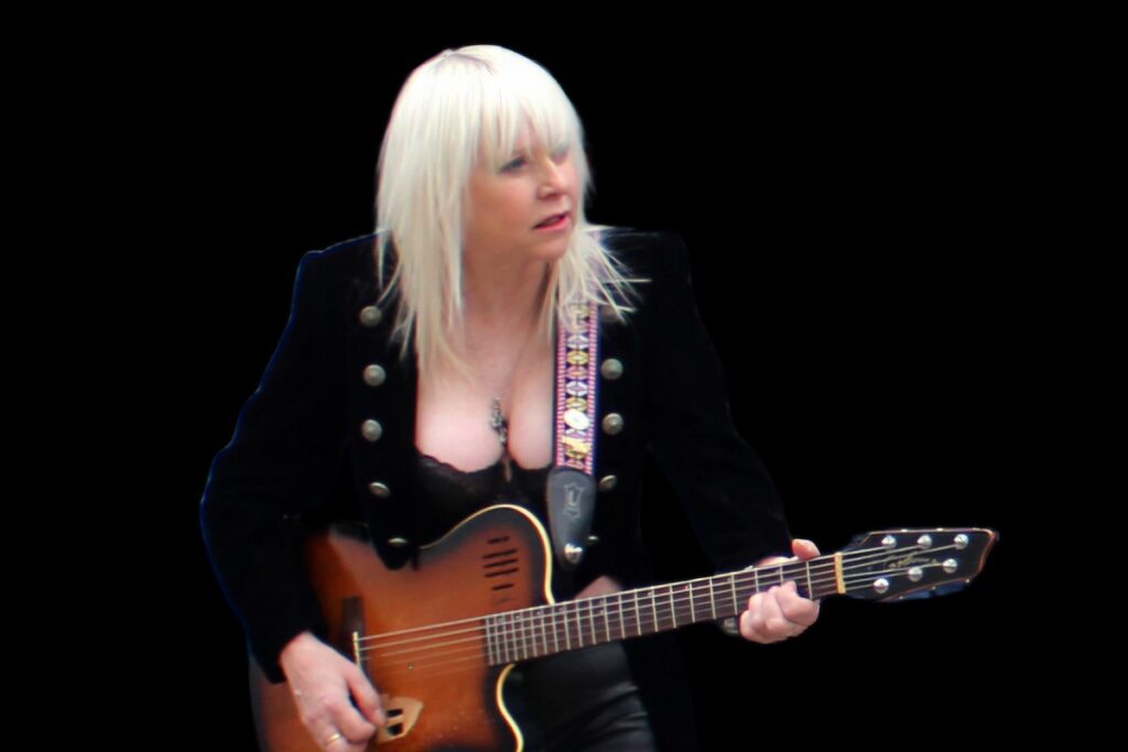 blonde woman posing with electric guitar