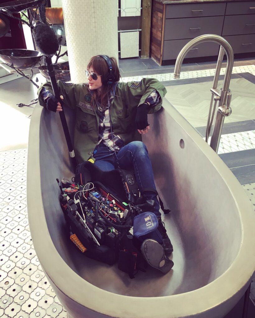Hannah Fairlight sitting in a bathtub with sound gear, ready for recording
