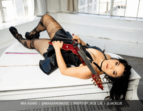 January page of the 2026 Guitar Girl Magazine calendar featuring violinist Mia Asano lying on a piano while holding an electric violin.