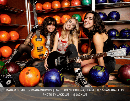 November page of the 2026 Guitar Girl Magazine calendar featuring the band Madam Bombs posing with guitars and bass among bowling balls in a bowling alley.