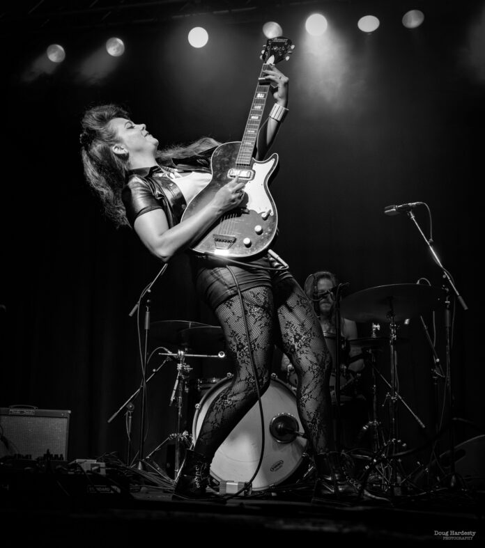 Ghalia Volt performing live onstage with electric guitar during an energetic blues-rock performance